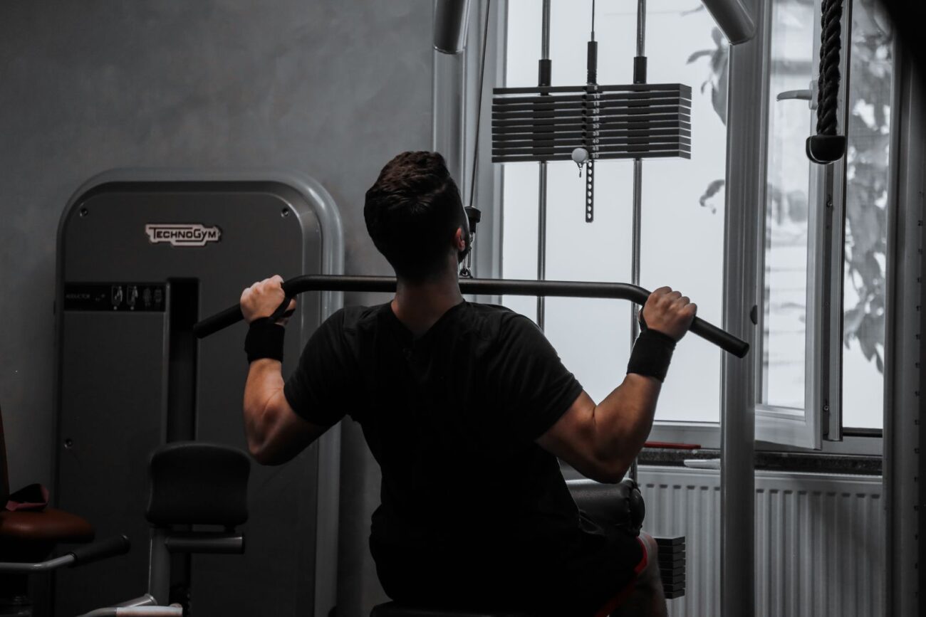 A man performing a lat pulldown in the gym, illustrating structured training for muscle gain