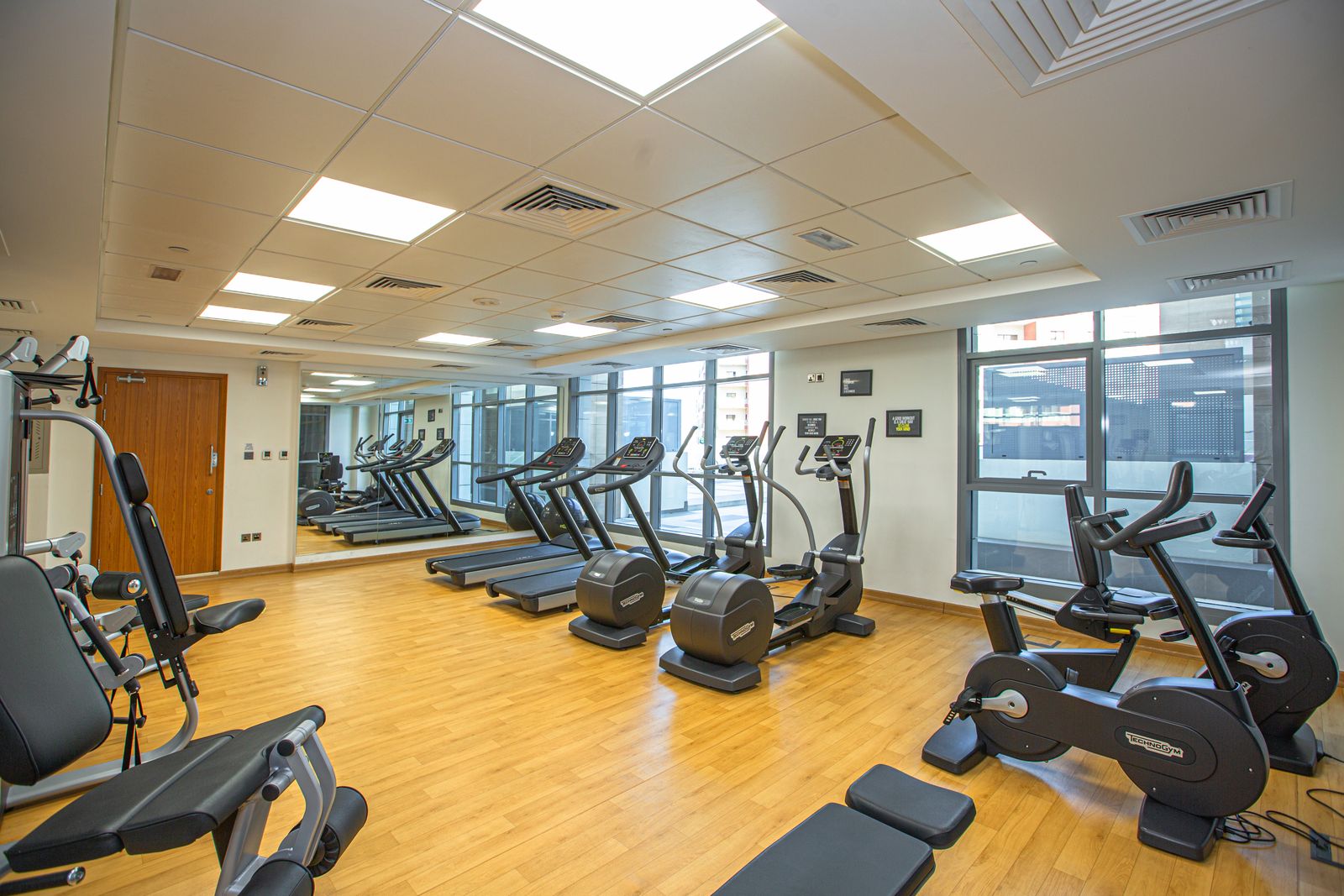Gym floor with cardio machines, benches, and strength equipment
