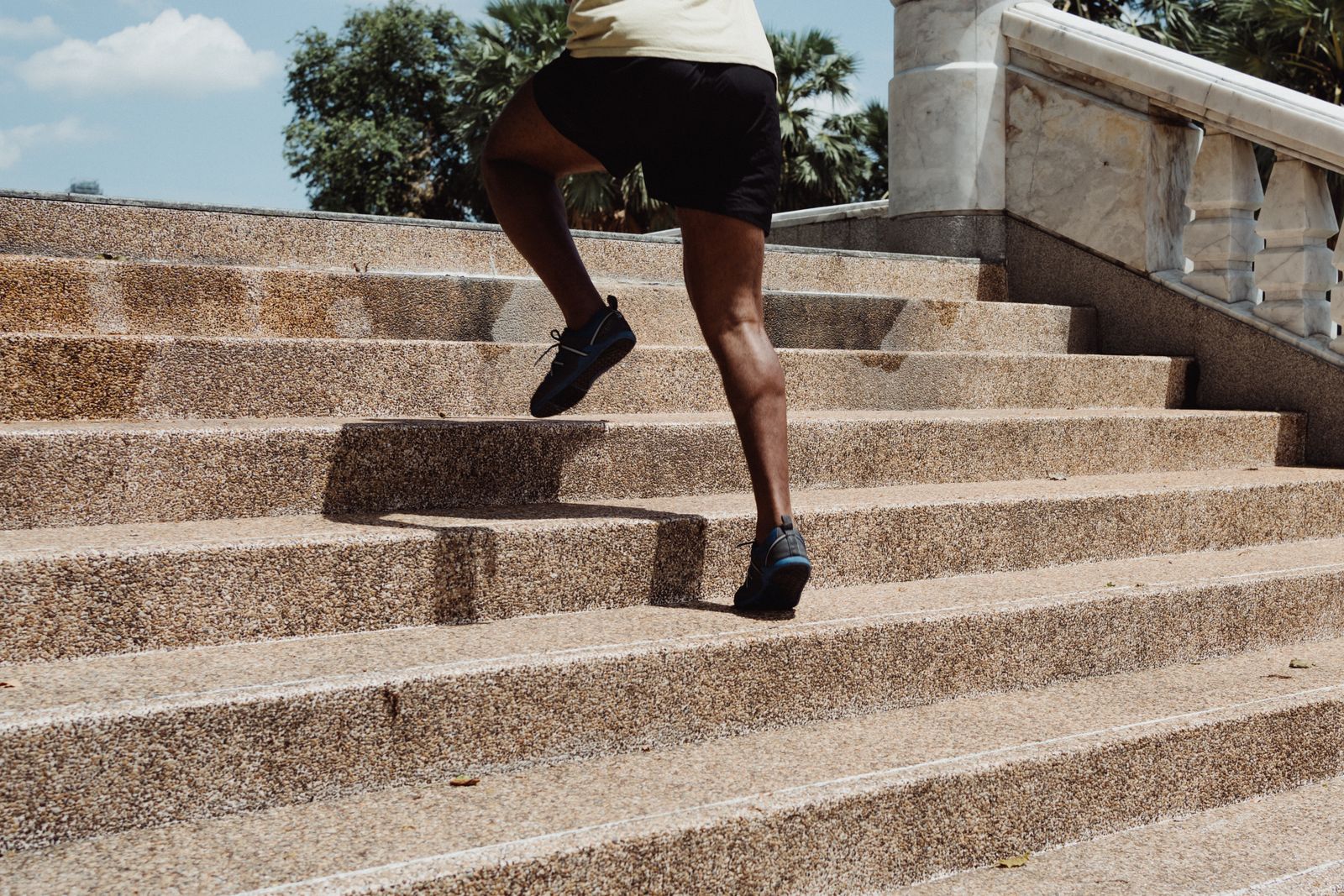 A person running up outdoor stairs, showing the regular cardio that helped balance training and stay lean