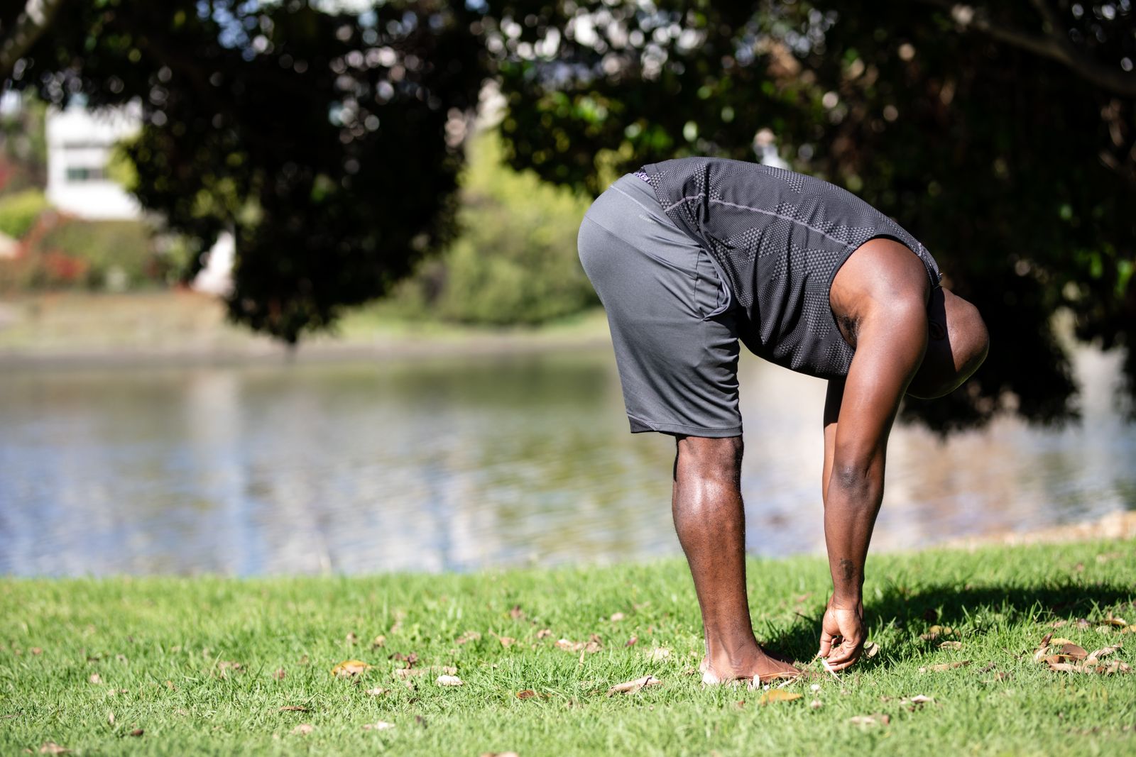 A person stretching outdoors by the water, showing the calm, clear-headed feeling that morning movement brings