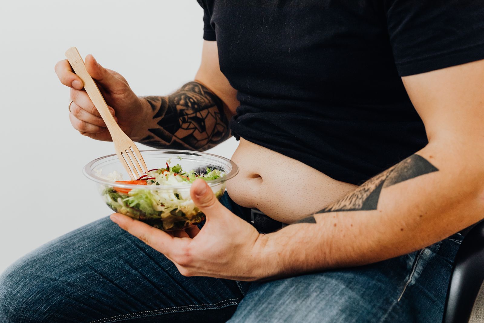 A person eating a fresh salad, illustrating that diet is the main driver of fat loss