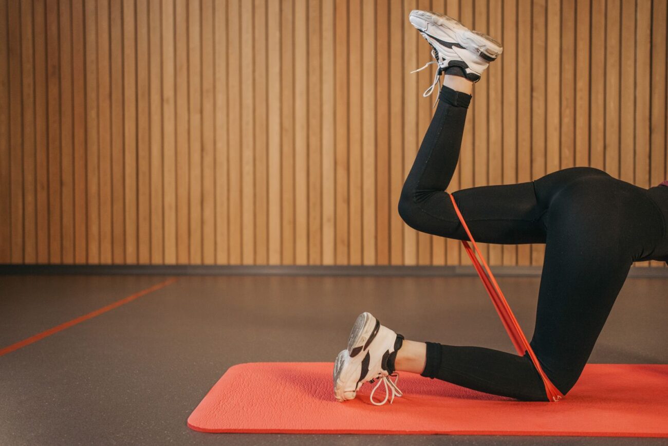 A person doing a resistance-band glute exercise on a mat, targeted training for the glutes