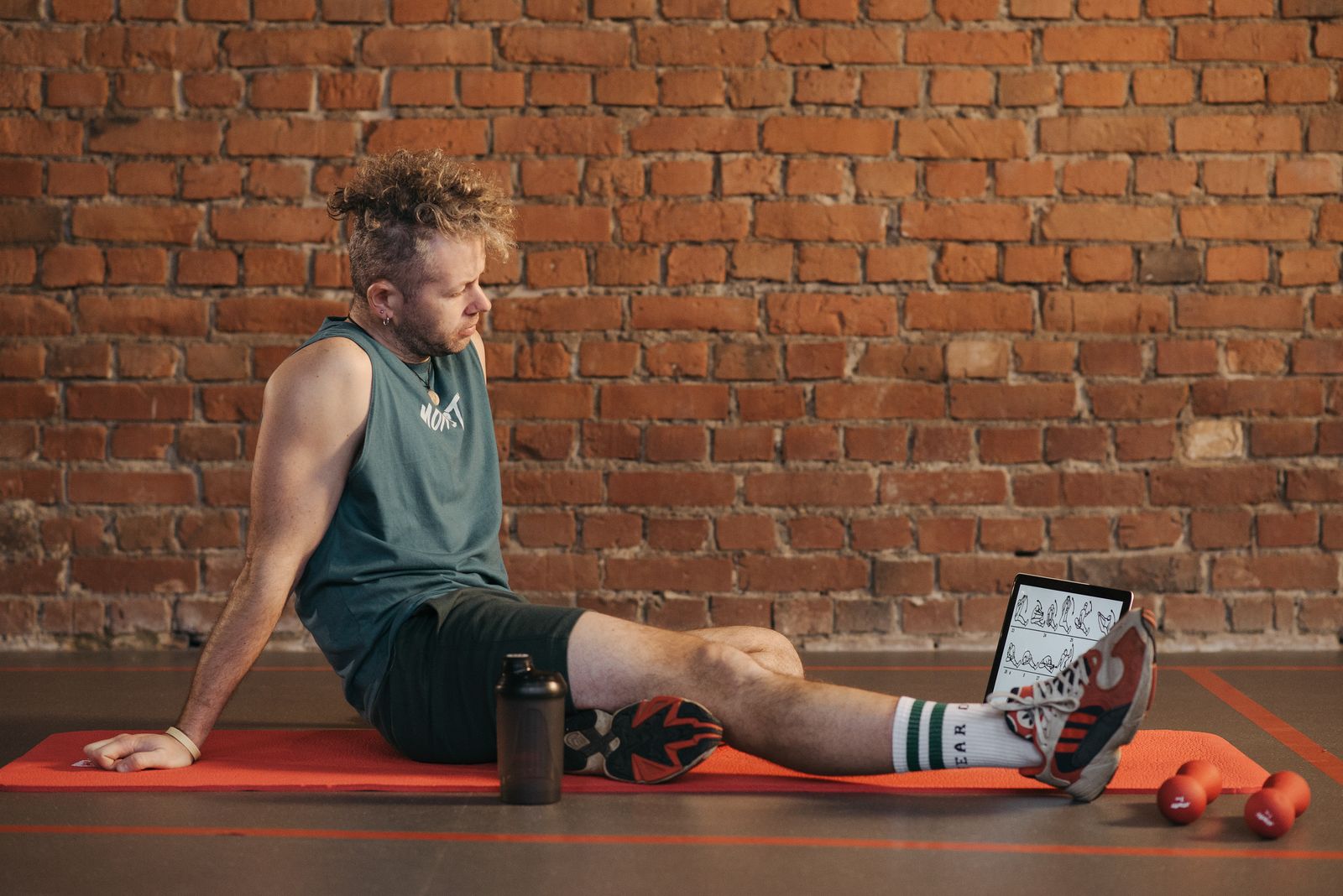  A person resting on a mat during a workout break, illustrating the recovery practices that support natural muscle building
