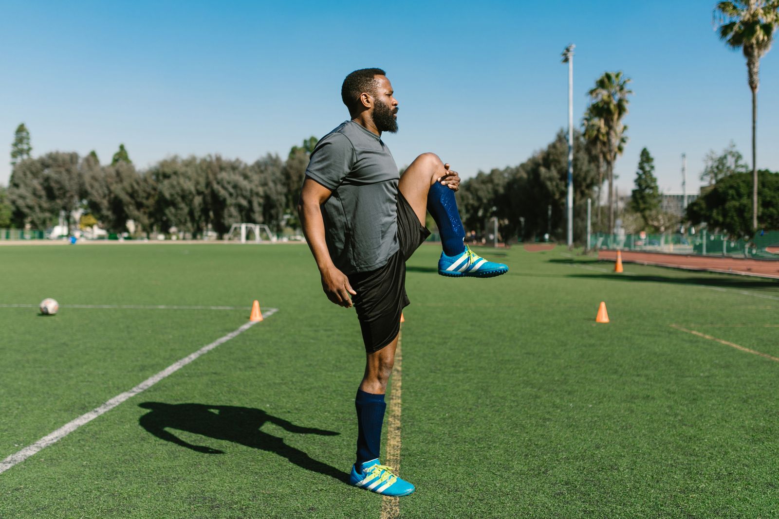 Man doing a standing balance stretch outdoors to maintain flexibility