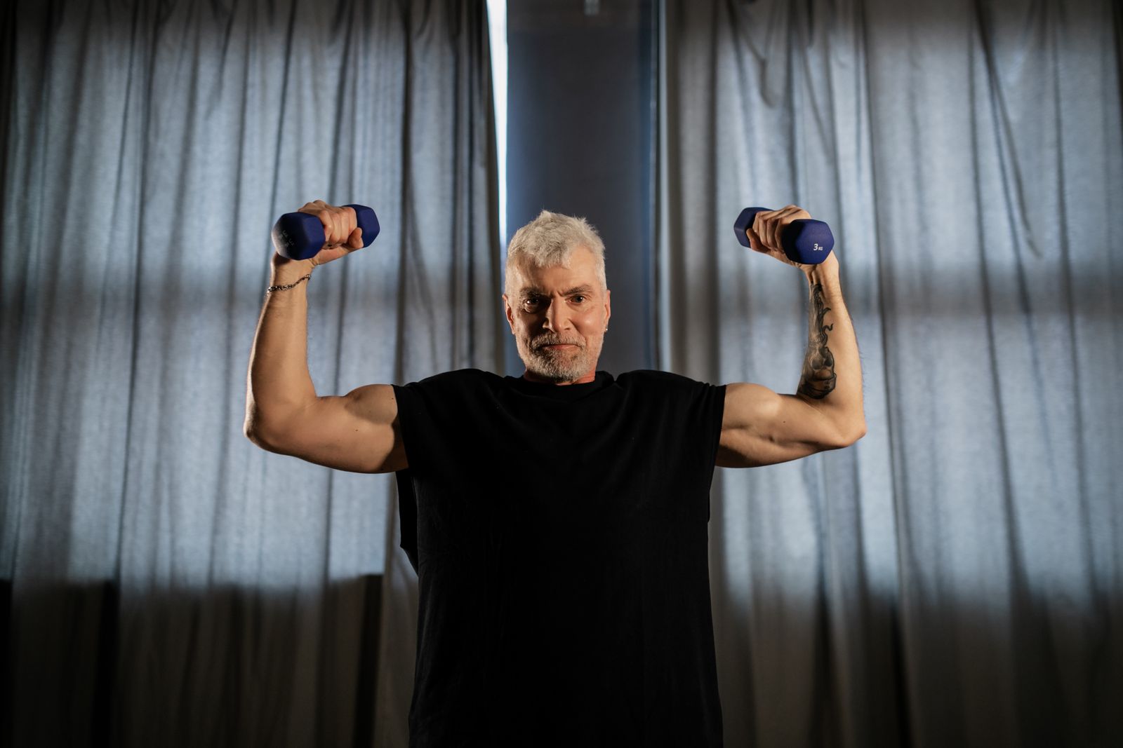 Older man training with dumbbells to build and keep muscle