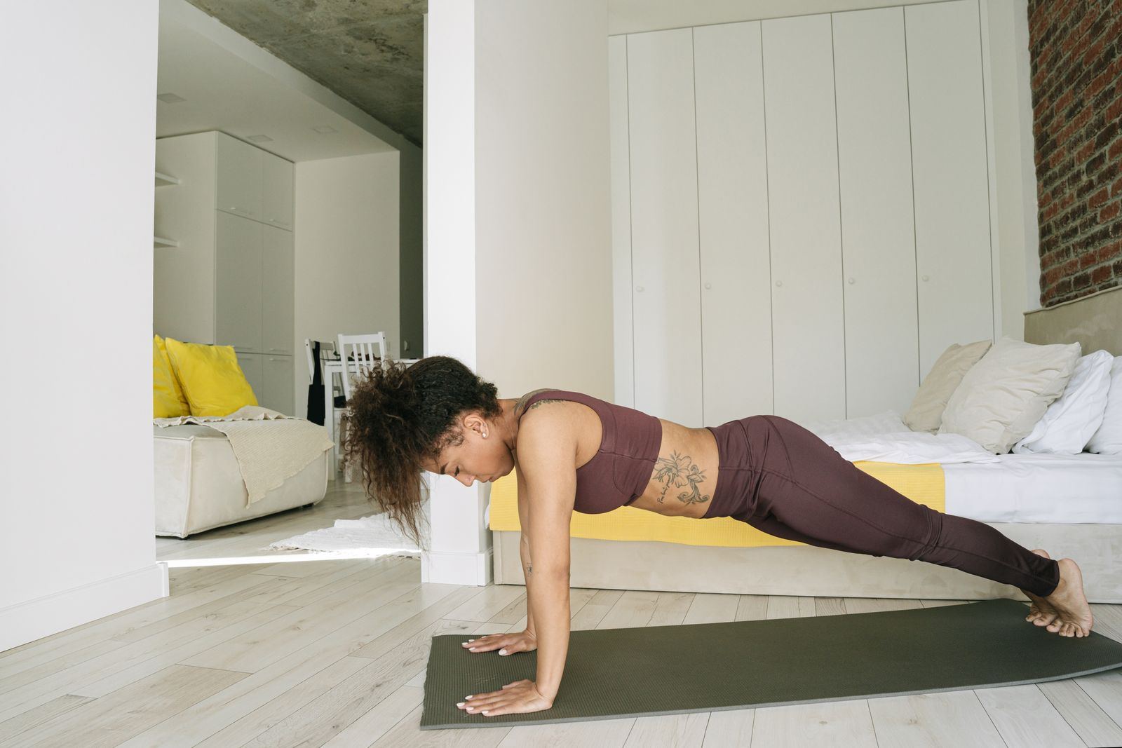 A woman doing a plank on a mat at home, a bodyweight exercise that needs no equipment