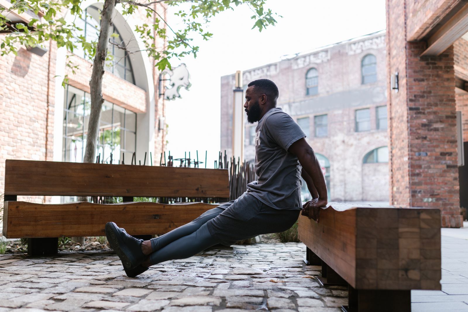 A man doing bench dips outdoors, showing the kind of bodyweight upper-body work that still builds strength for experienced lifters