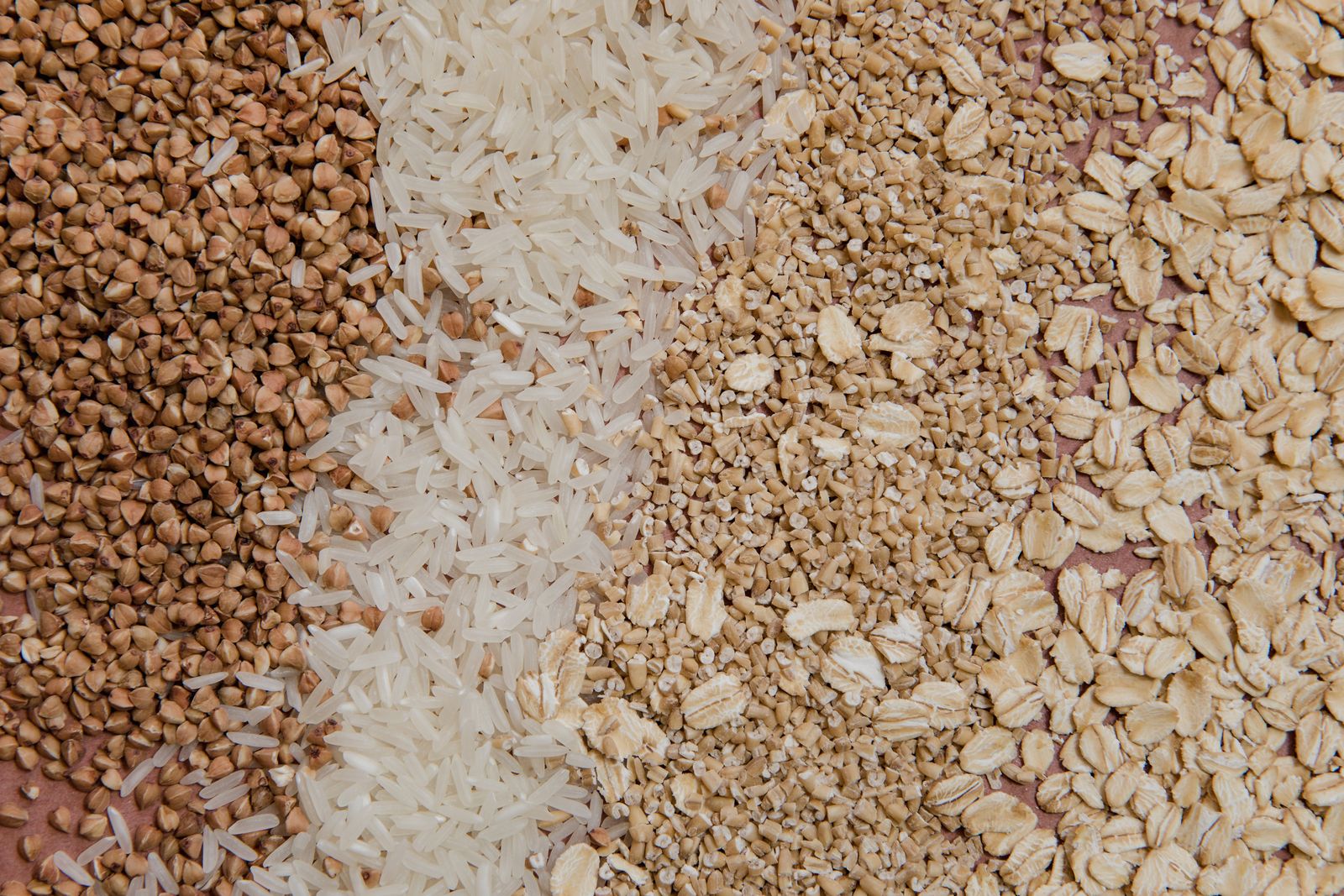 A spread of whole grains including buckwheat, rice, and oats, which digest slower and keep you fuller for longer