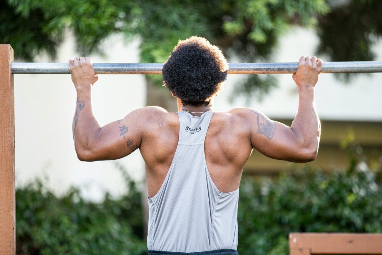 Man performing a pull-up on an outdoor bar with controlled form