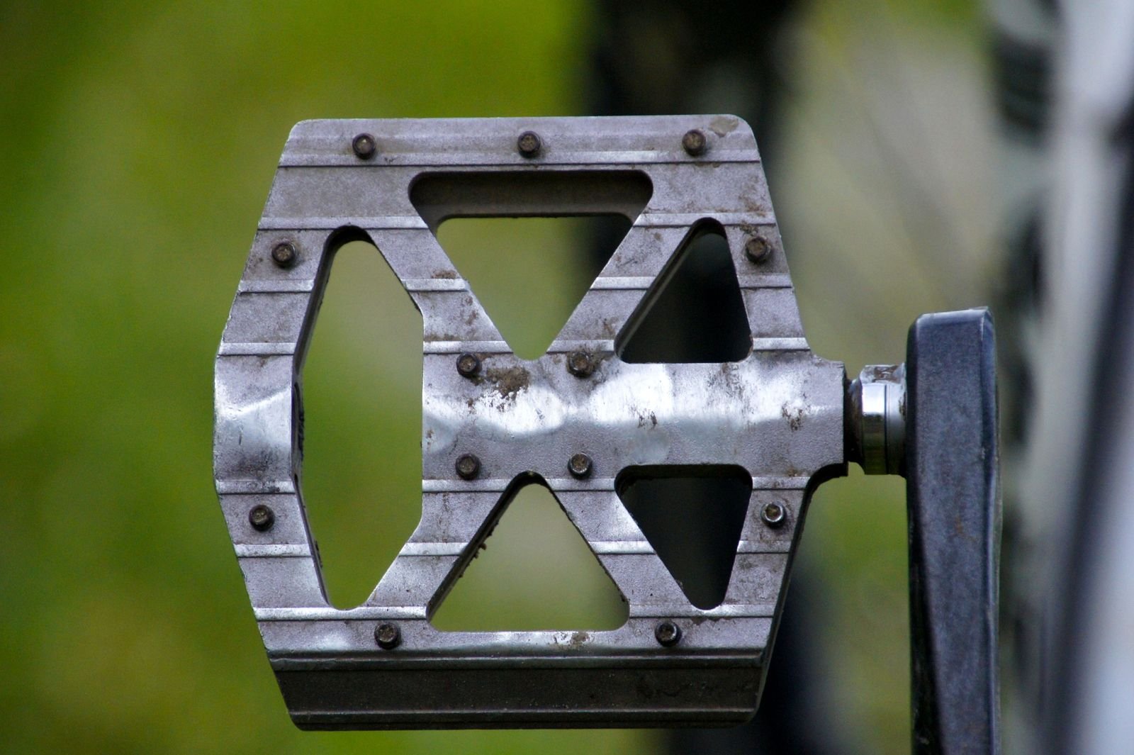 Close-up view of a metal exercise pedal with textured non-slip grips for mini bike arm workouts