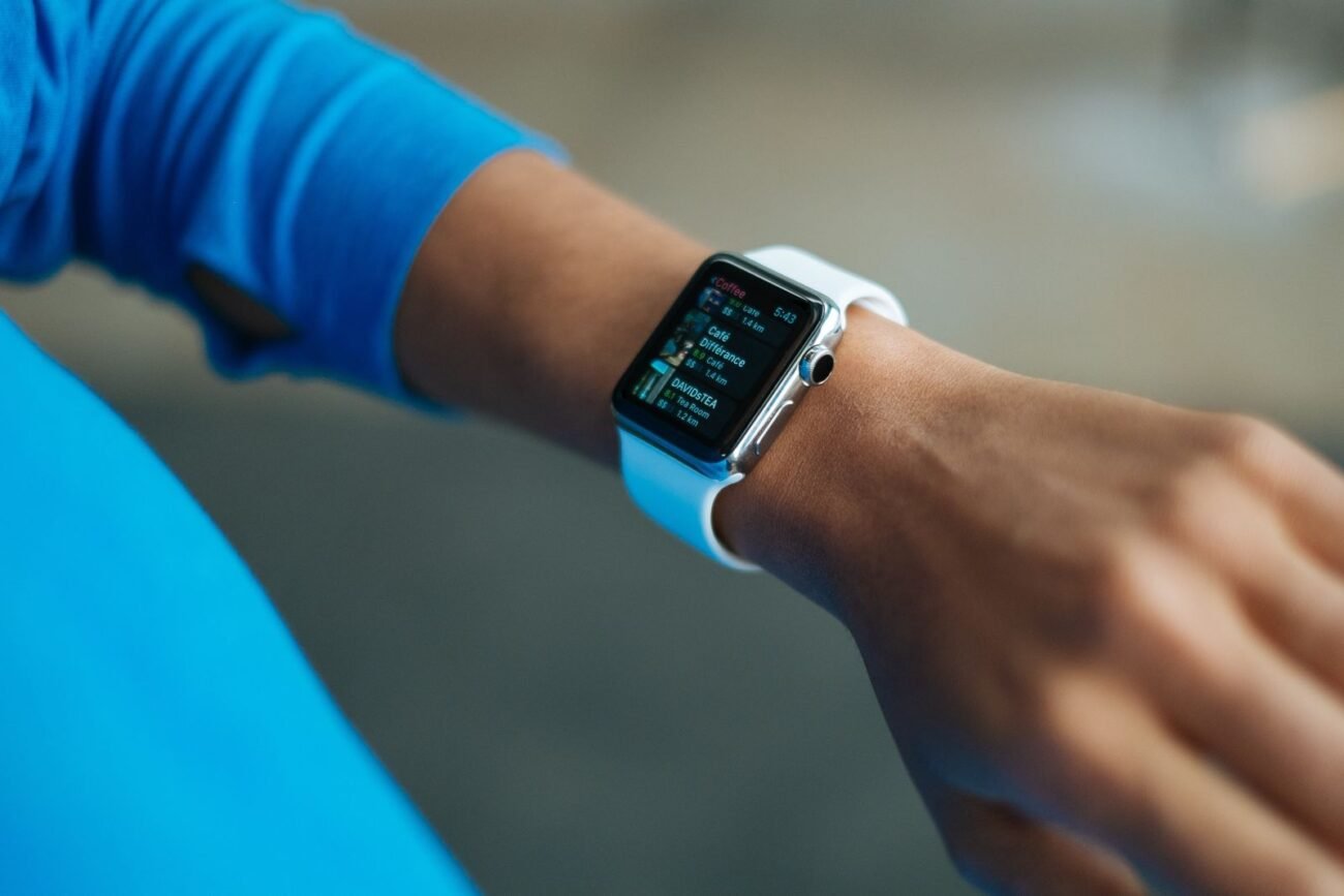 Close-up of a person wearing a smartwatch with a white band displaying fitness metrics during a workout